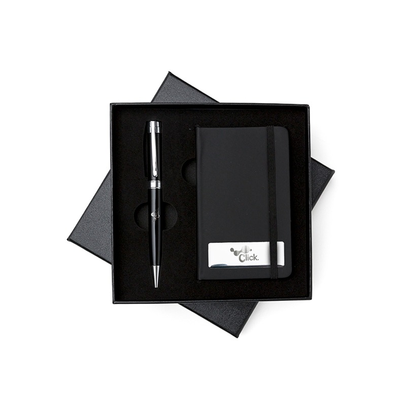 Kit executivo 2 peças em estojo de papelão com tampa e parte interna revestida de espuma. Contém: caneta metal preta com anel, detalhes em prata e escrita preta; caderneta emborrachada com aproximadamente 80 folhas amarelas com pauta. Acompanha placa metálica para gravação.
Altura : 17 cm
Largura : 17 cm
Medidas aproximadas para gravação (CxL): Placa 5,8 cm x 1,9 cm – Caneta 3,8 cm x 0,8 cm – Caderneta 12,5 cm x 7,5 cm